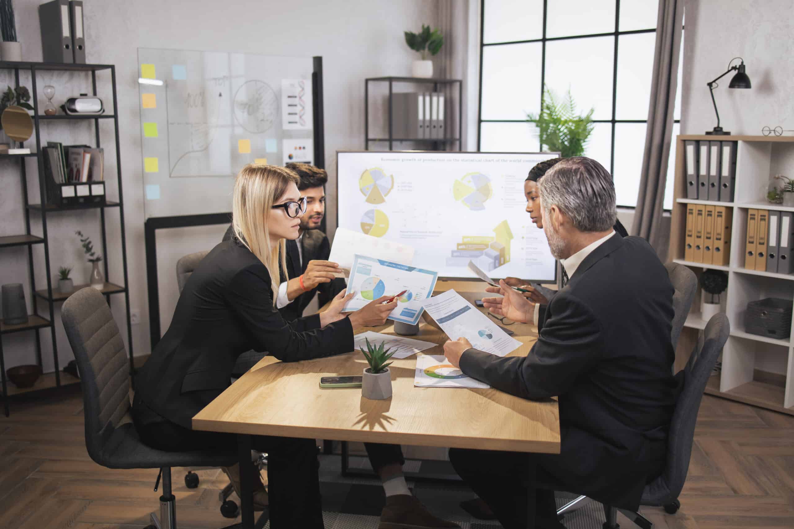 Attractive female woman, showing infographics and financial charts on the paper during meeting